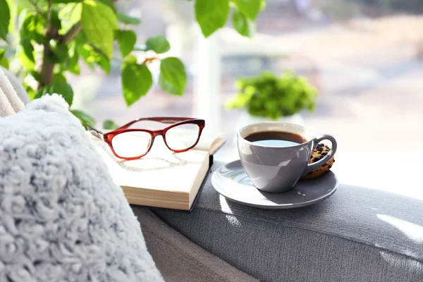 Kopje koffie met boek op sofa in kamer — Stockfoto