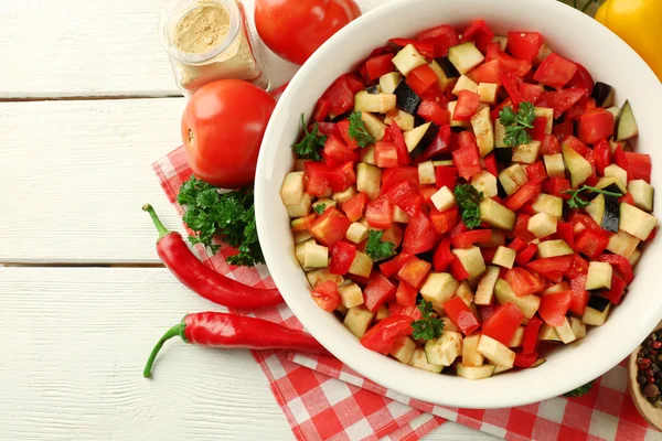 Ratatouille before cooking and ingredients, on wooden background — Stock Photo, Image