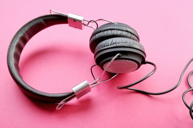 Pembe bir arka plan üzerinde siyah kulaklık