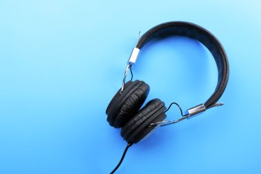 Mavi arka plan üzerinde siyah kulaklık