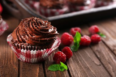 Çikolata cupcakes ve ahududu ahşap arka plan üzerinde