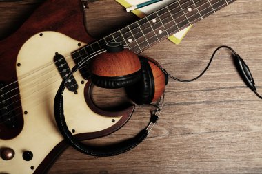 Elektro gitar ve ahşap arka plan üzerinde kulaklık