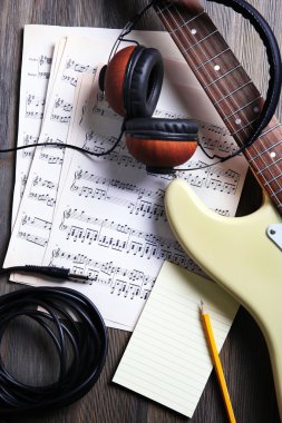 Elektro gitar nota ahşap zemin üzerinde ve kulaklık ile