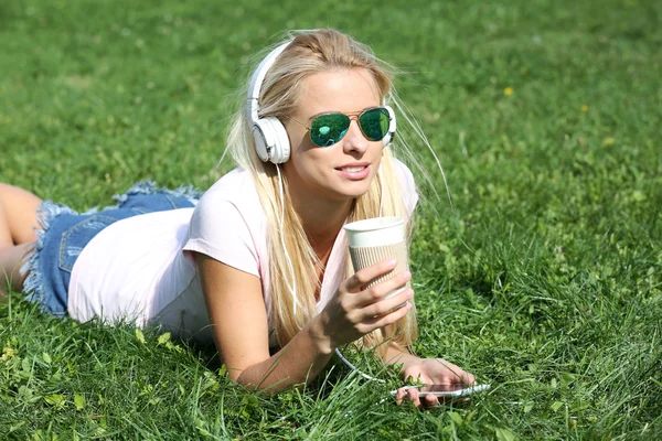 Kvinna med hörlurar och smartphone — Stockfoto