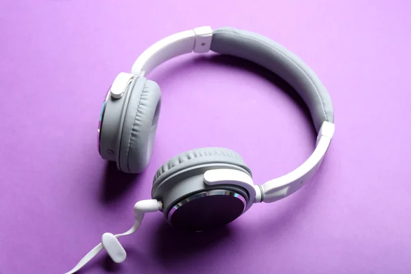 紫色背景上的白色和灰色的耳机 — 图库照片