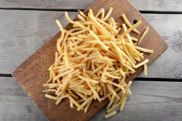 Pommes frites kartofler på skærebræt - Stock-foto