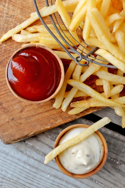 Bratkartoffeln in Metallkorb auf hölzernem Hintergrund — Stockfoto