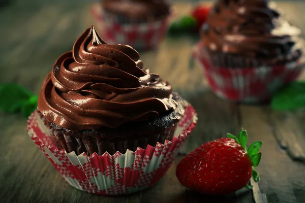 Schokolade Cupcakes und Erdbeeren auf Holz Hintergrund — Stockfoto