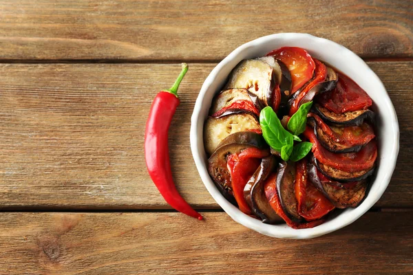 Ratatouille w misce, na tle drewniany stół — Zdjęcie stockowe