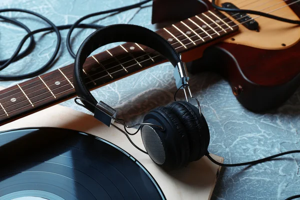 Guitare électrique et écouteurs avec accessoires de musique sur fond gris — Photo