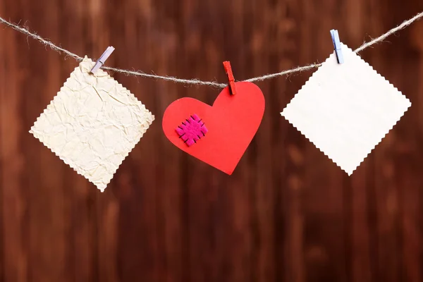 Corazón rojo y notas en blanco, sobre fondo de madera — Foto de Stock