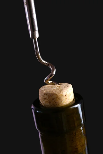 Sacacorchos y botella de vino sobre fondo negro —  Fotos de Stock