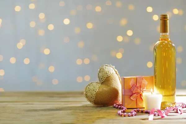 Instelling van een fles wijn, een geschenk in het vak en andere decoratie, op onscherpe achtergrond — Stockfoto