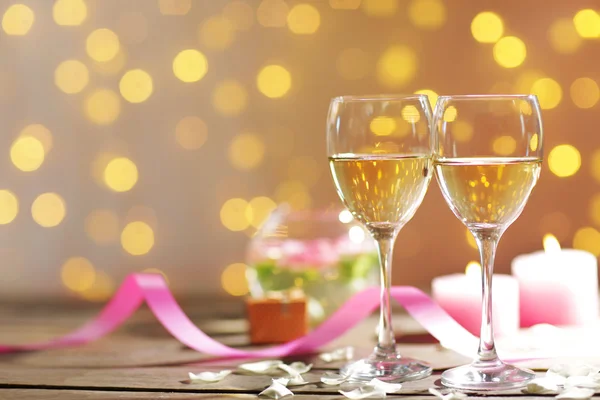 Glasses of wine, white roses and candles, on blurred background — Stock Photo, Image