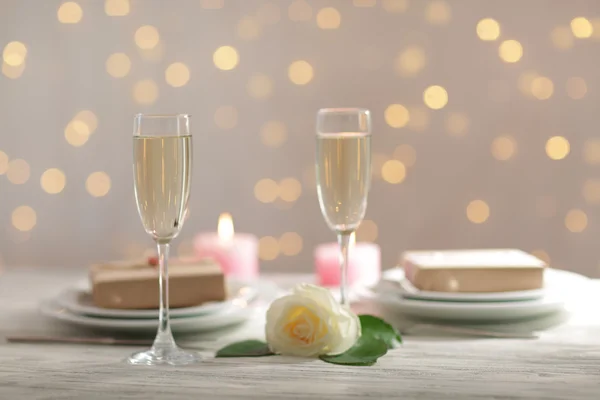 Glasses of wine and a white rose, on blurred background — Stockfoto