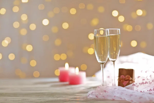 Bicchieri di vino, un regalo nella scatola e candele, su sfondo sfocato — Foto Stock