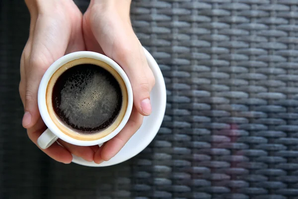 Secangkir kopi dengan tangan di atas meja latar belakang — Stok Foto