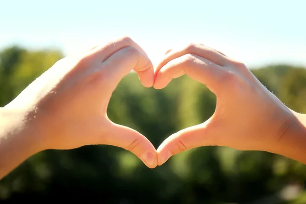 La mujer sostiene las manos en forma de corazón —  Fotos de Stock