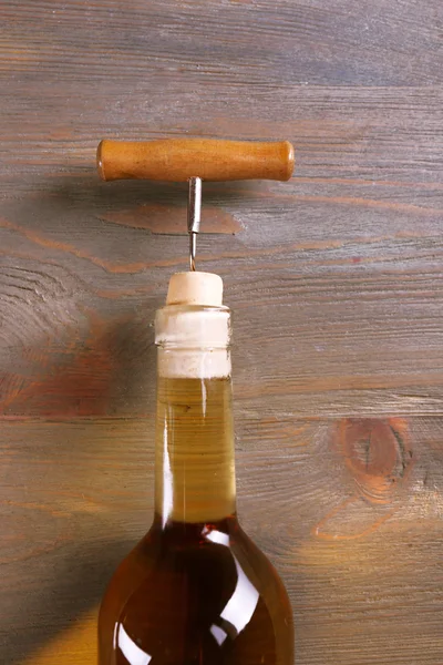 Sacacorchos y botella de vino sobre fondo de madera —  Fotos de Stock