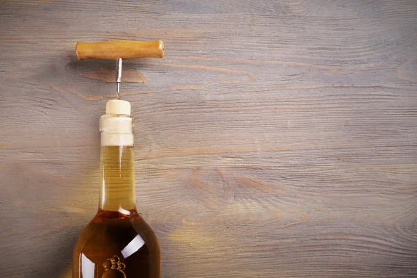 Sacacorchos y botella de vino sobre fondo de madera —  Fotos de Stock