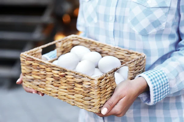 Huevos en cesta en manos de mujer —  Fotos de Stock
