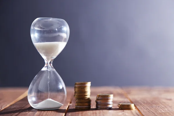 Antique Hourglass with coins — Stock Photo, Image