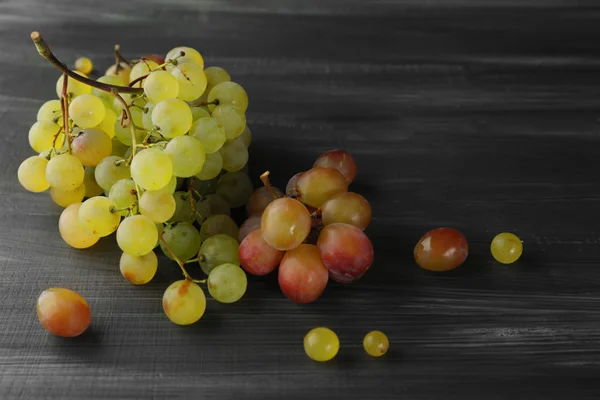 Sappige groene en paarse druiven, op houten achtergrond — Stockfoto