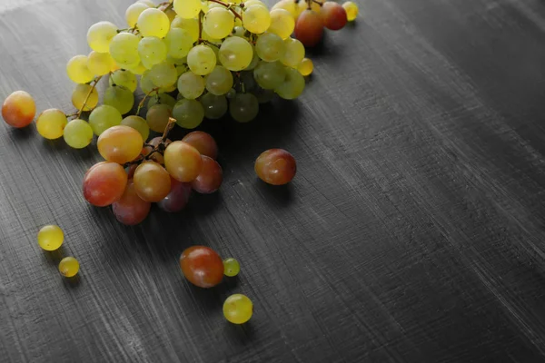 Uvas jugosas verdes y moradas, sobre fondo de madera —  Fotos de Stock