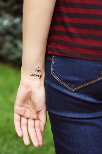 Mano de mujer joven con frase tatuada — Foto de Stock