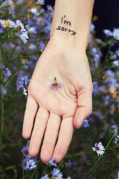 Hand of young woman with tattooed phrase