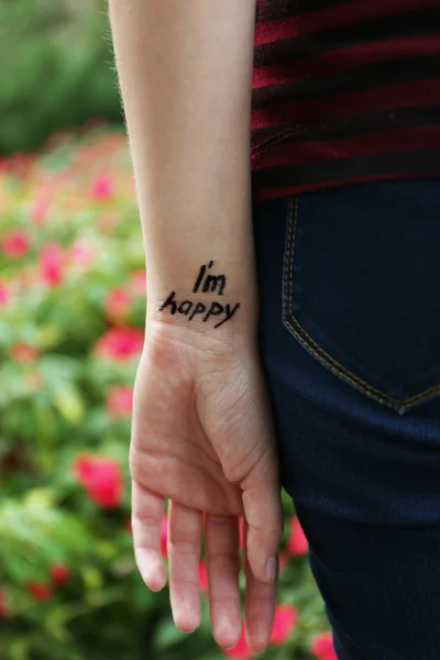 Рука молодої жінки з татуюванням фразою — стокове фото