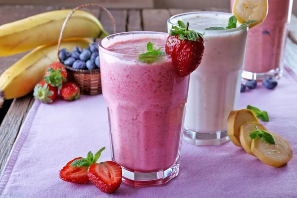 Bicchieri di frullato fresco freddo con frutta e bacche, sul tavolo, primo piano — Foto Stock