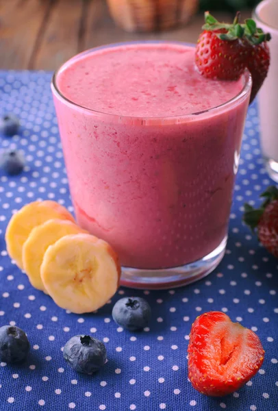 Lunettes de smoothie frais froid aux fruits et baies, sur fond de nappe bleue — Photo