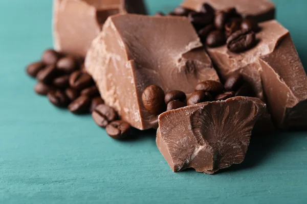 Milk chocolate pieces and coffee grains — Stock Photo, Image