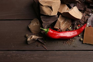 Biber ahşap arka plan üzerinde siyah çikolata parçaları