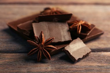 İle baharat ahşap arka plan üzerinde siyah çikolata parçaları