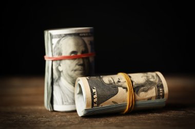 Koyu arka plan önünde ahşap masa dolar rulo