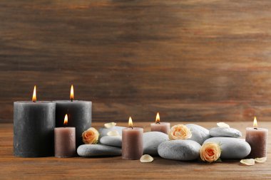 Ahşap arka plan üzerinde gri mum gül ve çakıl yanıyor - kavramı relax