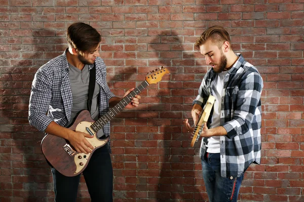 Hombres jóvenes tocando guitarras —  Fotos de Stock