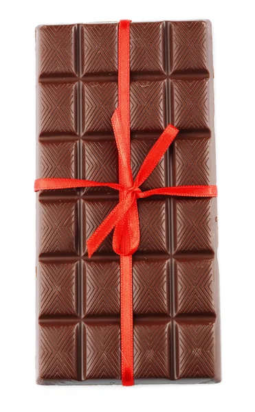 Barra de chocolate de leite com arco vermelho na cor de fundo de madeira — Fotografia de Stock