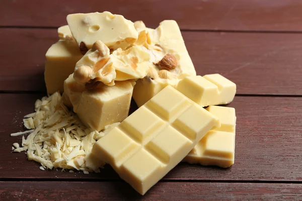 Witte chocolade stukjes met noten op een houten achtergrond kleur — Stockfoto