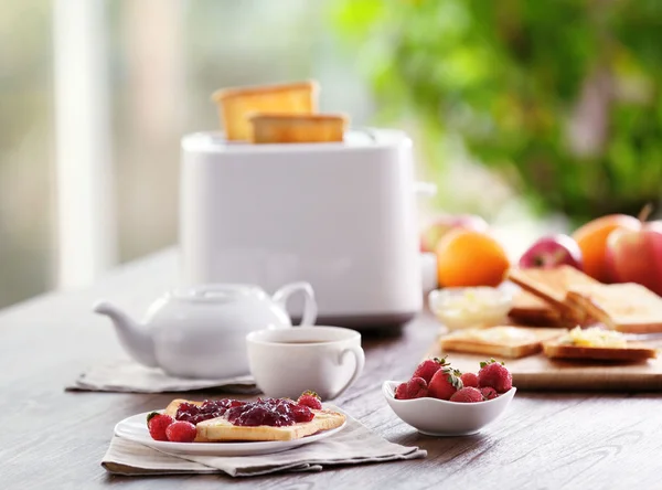 Podává tabulka k snídani s toasty, kávu a ovoce, na rozmazané pozadí — Stock fotografie