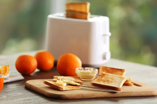 Served table for breakfast with toast and fruit, on blurred background — Stock Photo, Image