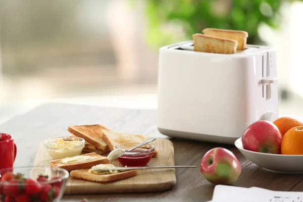 Tavola servita a colazione con pane tostato e frutta, su fondo sfocato — Foto Stock