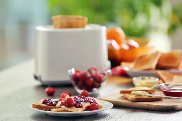 Mesa servida para el desayuno con tostadas y fruta, sobre fondo borroso — Foto de Stock