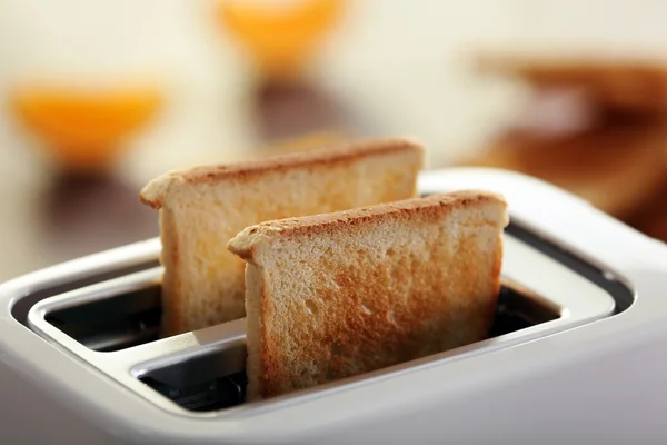 Meja sajian untuk sarapan dengan roti panggang dan jus jeruk, dengan latar belakang kabur — Stok Foto