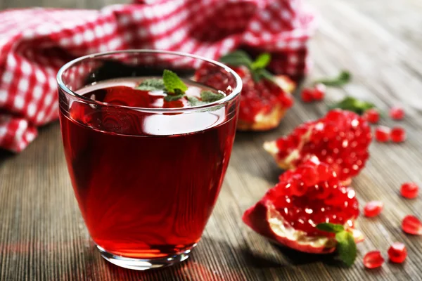 Un verre de jus savoureux et de fruits grenat, sur fond bois, gros plan — Photo