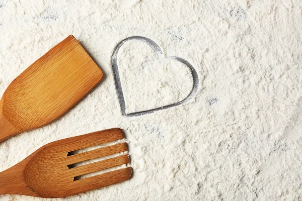 Coeur de farine et ustensiles de cuisine en bois n sur fond gris — Photo