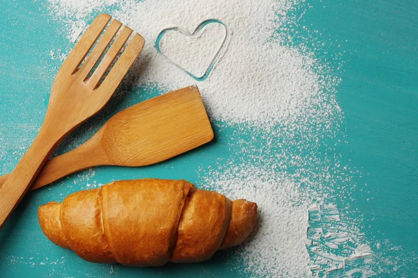 Heart of flour, croissants on color wooden background — Stock Photo, Image