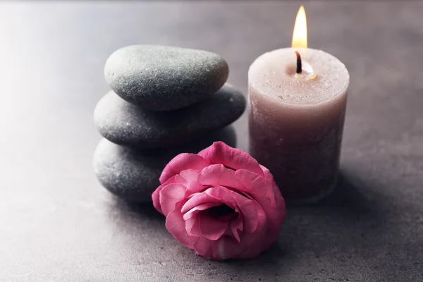 Bougie d'arôme avec cailloux et fleur sur fond gris — Photo